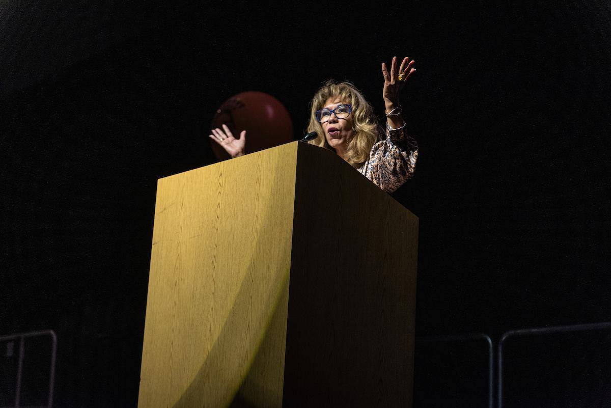 President Teniente-Matson stands at a podium delivering a speech.